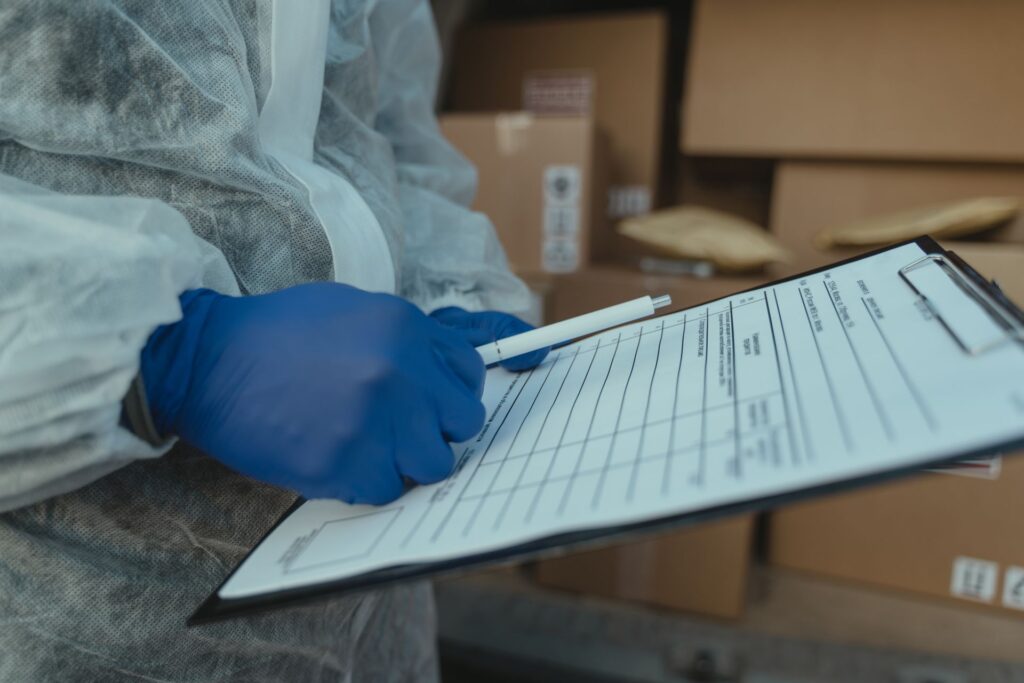 Hnads of a Person Wearing Gloves Holding a Pen and Paper
